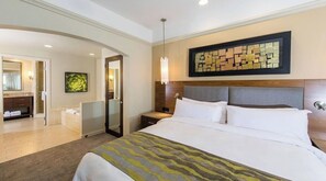 Relax in comfort with a large bed, nightstand, and wall-mounted lamp, accompanied by a modern artwork and mirror.