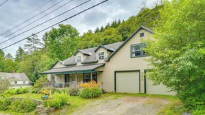 A two-story house with a porch, a garage, and a driveway leading to a stone wall. - Londonderry Retreat ~ 3 Mi to Lowell Lake! (Londonderry)