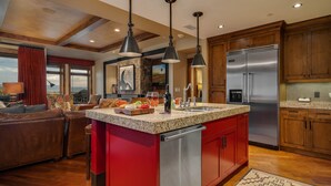 A modern kitchen with a central island, stainless steel appliances, and wooden cabinetry. - Steamboat Square Views | One Steamboat Place 512 (Steamboat Springs)