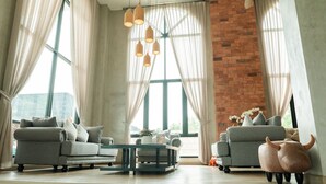 Een moderne woonkamer met twee banken, een bijzettafeltje en een decoratief varkensbeeldje.