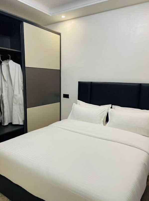 Habitació d'hotel amb un llit, un armari i un mirall.