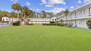 Un hotel con un patio central, varios pisos y una zona de piscina.