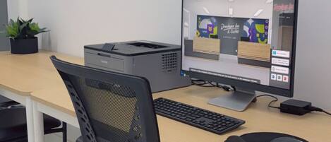 A modern office desk with a computer, keyboard, mouse, and chair.