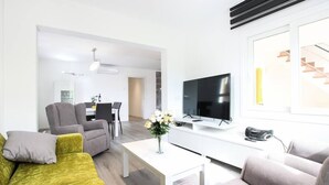 A modern living room with a sofa, armchairs, a coffee table, and a TV. - Apartamento Rieres, Modern apartment next to the beach Port Pollensa (Port de Pollença)