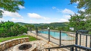 A stone pool with a stone fire pit and a fenced patio area. - Hillside views, private swimming pool, less than 5-minute drive to THE Frio River (Concan)