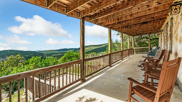 A wooden deck with a view of green hills and a clear sky. - Hillside views, private swimming pool, less than 5-minute drive to THE Frio River (Concan)