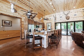 A spacious kitchen with wooden cabinets, a central island, and a seating area with bar stools.