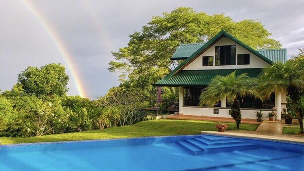 A two-story house with a green roof, a swimming pool, and lush greenery. - 4 bdrs, Casa Shanti, ocean view & large pool! (Savegre de Aguirre)
