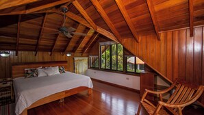 A bedroom with a wooden ceiling, a bed, a chair, and a window with a view of greenery. - 4 bdrs, Casa Shanti, ocean view & large pool! (Savegre de Aguirre)