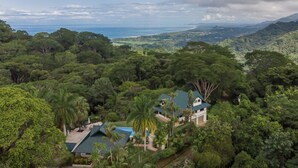 A tropical resort with lush greenery, a pool, and a view of the ocean. - 4 bdrs, Casa Shanti, ocean view & large pool! (Savegre de Aguirre)