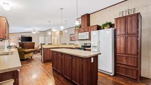 Een moderne keuken met houten kastjes, een centraal eiland en ingebouwde apparatuur.