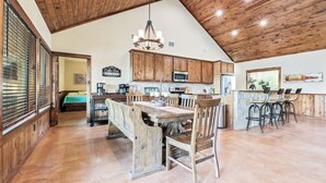 A spacious kitchen with wooden cabinets, a central island, and bar stools. - Private swimming pool, huge outdoor entertainment area, less than 5-minute drive to THE Frio River (Concan)