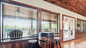 A rustic interior with large windows, wooden barrel, and a door leading outside. - Private swimming pool, huge outdoor entertainment area, less than 5-minute drive to THE Frio River (Concan)