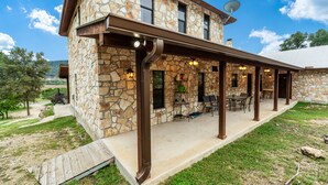 A stone building with a covered patio, outdoor seating, and a satellite dish. - Right in the heart of Concan, private swimming pool, epic views & a 2-minute drive to THE Frio River (Concan)