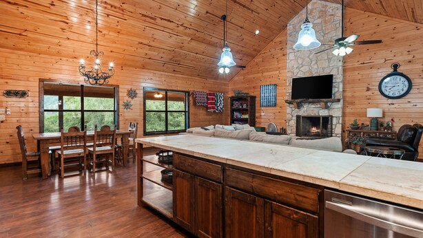 A wooden interior with a dining area, kitchen, and living space. - Right in the heart of Concan, private swimming pool, epic views & a 2-minute drive to THE Frio River (Concan)