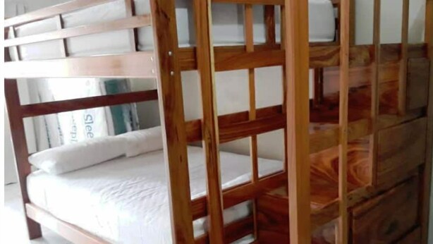 A bunk bed with a wooden frame and white bedding. - Apartamentos Amueblado (Corredores)