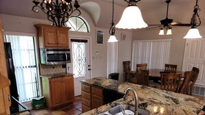 A kitchen with granite countertops, wooden cabinets, a built-in microwave, and a sink with a faucet. - Stone House with patio and less than 50 yards to the water. (Clifton)