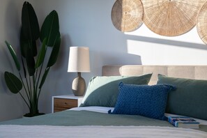 A neatly made bed with green bedding, a blue pillow, and a white lamp on a bedside table. - Luxury Home - Jacuzzi! Mini-Golf! Ping-Pong! Pets! 2 Desks! Yoga! Beach Gear! (North Palm Beach)
