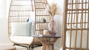 A room with a hanging chair, a round ottoman, and a small table with a vase and a book. - Luxury Home - Jacuzzi! Mini-Golf! Ping-Pong! Pets! 2 Desks! Yoga! Beach Gear! (North Palm Beach)