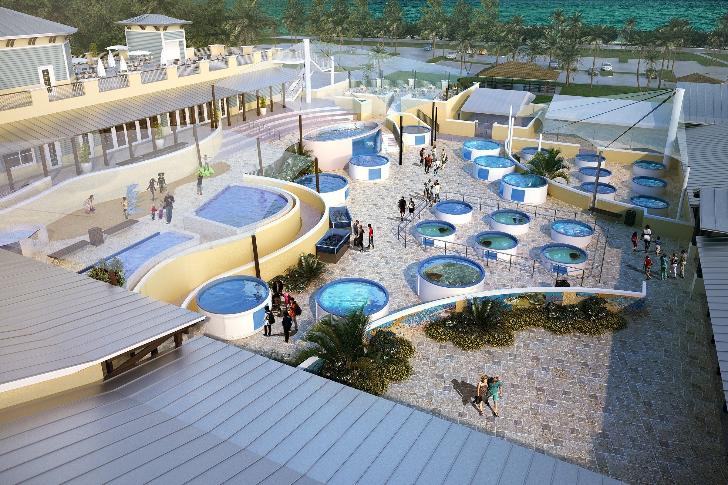 A resort with multiple swimming pools, a covered area with seating, and a view of the ocean.