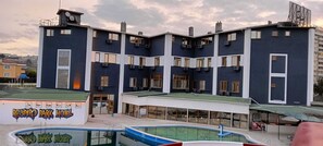 Un hôtel à plusieurs étages, doté d’un toit plat, de grandes fenêtres et d’une piscine située au premier plan.