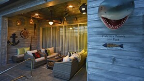 A cozy, nautical-themed lounge area with wicker furniture, a large anchor decoration, and a sign stating "Fish are Friends Not Food." - Charming 3Bd Pool TH The Enclaves at Festival-350CD-NEW (Davenport)