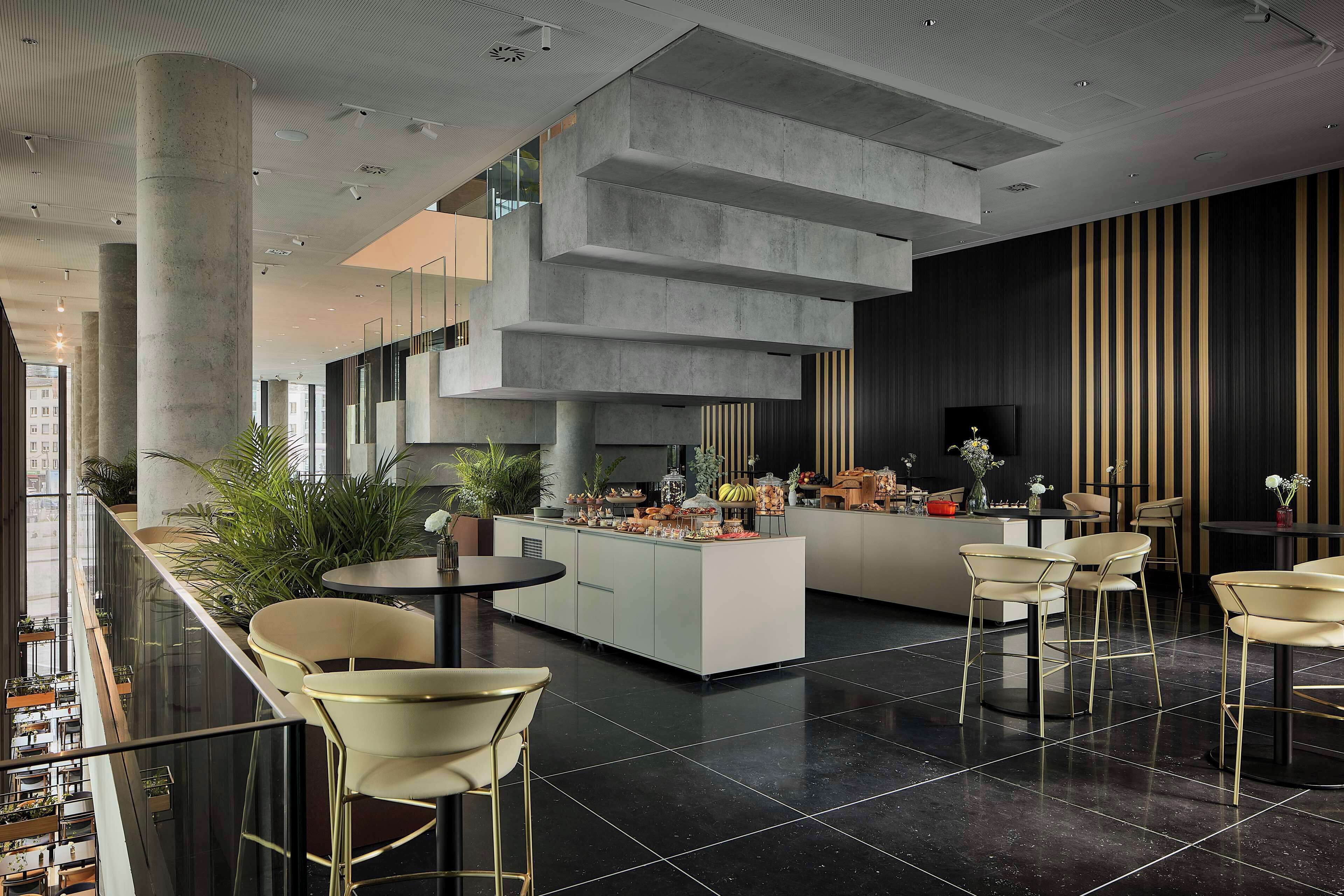 A modern interior with a central island, seating, and a view of the city.