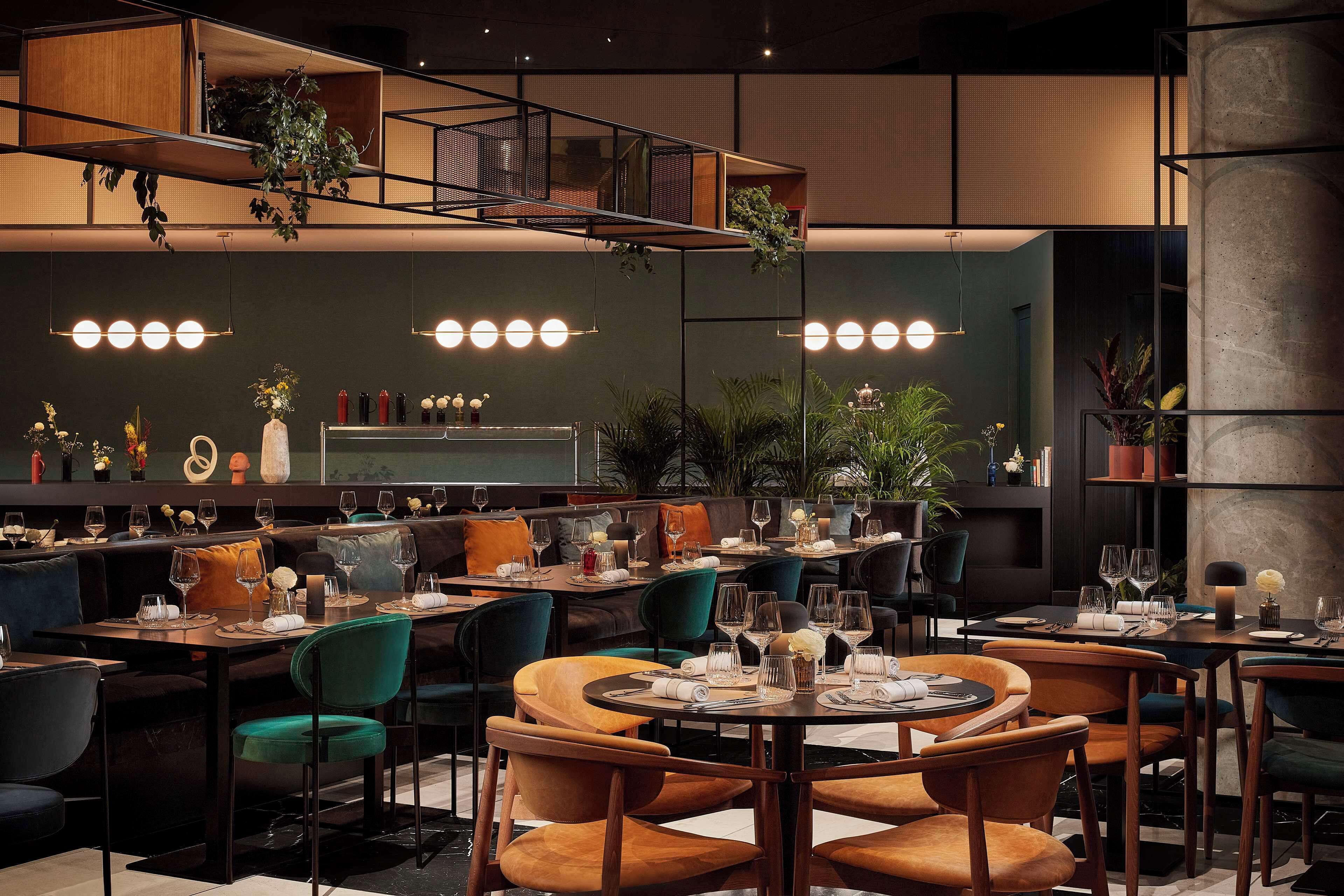Un restaurant moderne doté de plusieurs espaces de restauration, notamment des banquettes et des tables, et offrant une variété d’options d’aménagement.