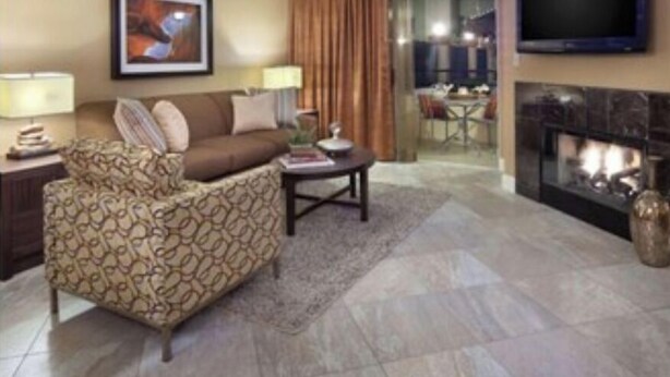 A living room with a sofa, a coffee table, a fireplace, a TV, and a dining area visible through a glass door. - In The Center Of It All, Right Next To The Sphere, Ten Minute Walk To The Strip (Las Vegas)