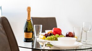 Una mesa con una botella de Canti Prosecco DOCG, un vaso de agua y una bandeja de fruta.