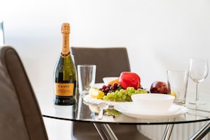 A table with a bottle of Canti Prosecco DOCG, a glass of water, and a fruit platter. - Birmingham City Centre - 2 Bed - Secure Parking
 (BIRMINGHAM)