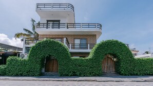 Een modern gebouw met twee verdiepingen, een plat dak en een balkon op de bovenste etage.