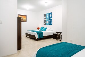 A bedroom with a bed, a bedside table, a lamp, and a wall with nautical-themed decor. - Starfish Hotel (Puerto Villamil)