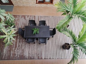 An outdoor dining area with a table and chairs, surrounded by potted plants. - Starfish Hotel (Puerto Villamil)