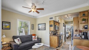 A compact living space with a sofa, coffee table, and a kitchenette area.
