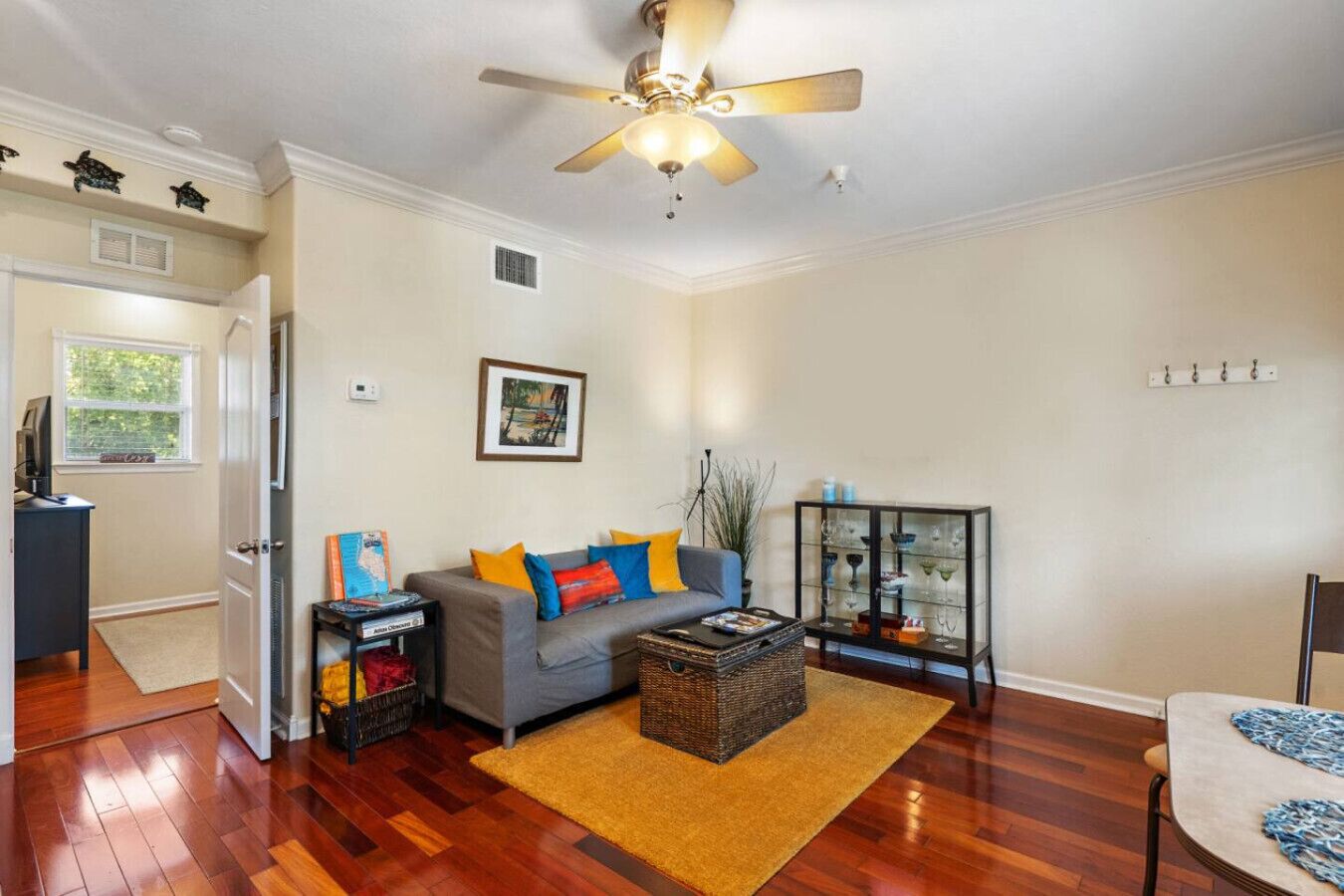 A living room with a grey sofa, a coffee table, and a glass cabinet with decorative items.