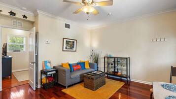 A living room with a grey sofa, a coffee table, and a glass cabinet with decorative items.