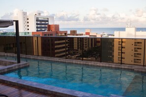 Una piscina con vista al mar y edificios circundantes.