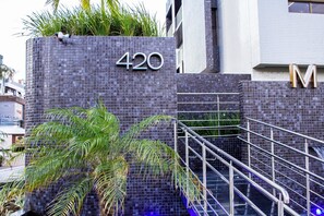 Un bâtiment sur lequel on peut voir un grand panneau indiquant le chiffre « 420 », un escalier en métal et un palmier.