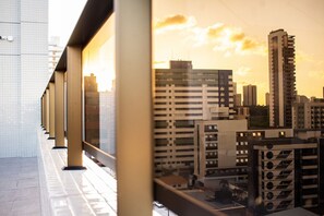A modern building with a glass facade, large windows, and a series of balconies. - Apart no Maradisa Design por Carpediem (João Pessoa)
