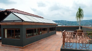 A modern building with large windows and a sloped roof. - Vista Del Sol Apartments (San Miguel de Allende)