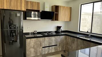 Fridge, microwave, coffee/tea maker, cookware/dishes/utensils