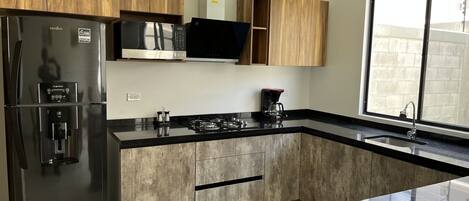 Fridge, microwave, coffee/tea maker, cookware/dishes/utensils