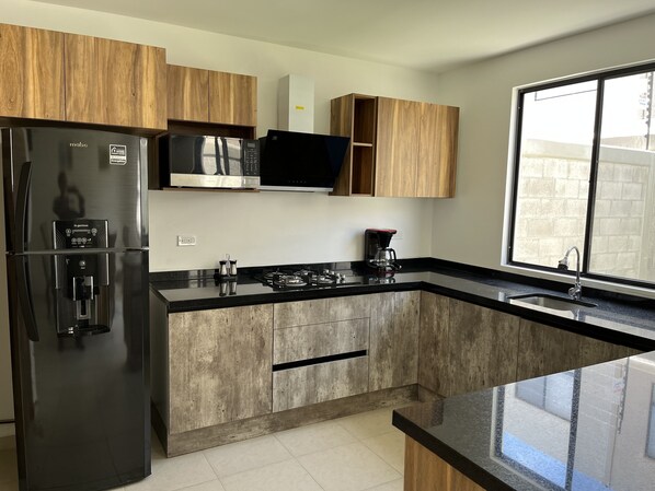 Refrigerador, microondas, cafetera y tetera y utensilios de cocina