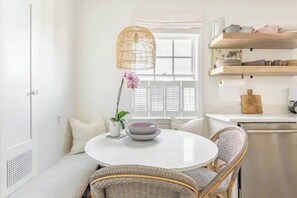 Cozy retreat with a round table, wicker chairs, and a potted plant.