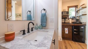 Una cocina moderna con encimera de mármol, grifo negro y armarios de madera.