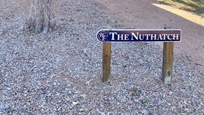 A rustic wooden cabin with a porch and a sign reading "The Nuthatch". - The Nuthatch Cabin (15 MIN to Magnolia & Baylor) (Elm Mott)