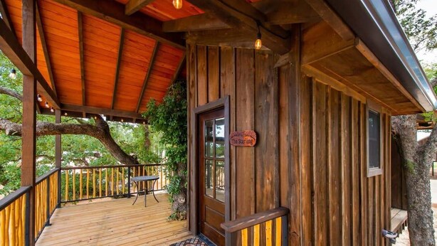 Una baita di legno con una veranda, una porta con su scritto "The Starling" e una finestra.