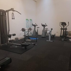 A gym with various exercise equipment including treadmills, stationary bikes, and weight machines. - Comfy 1-bed Apartment in Huddersfield (Huddersfield)