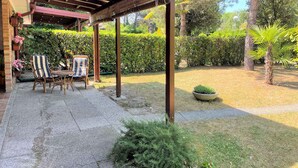 Un patio techado con un conjunto de asientos y un pequeño jardín.